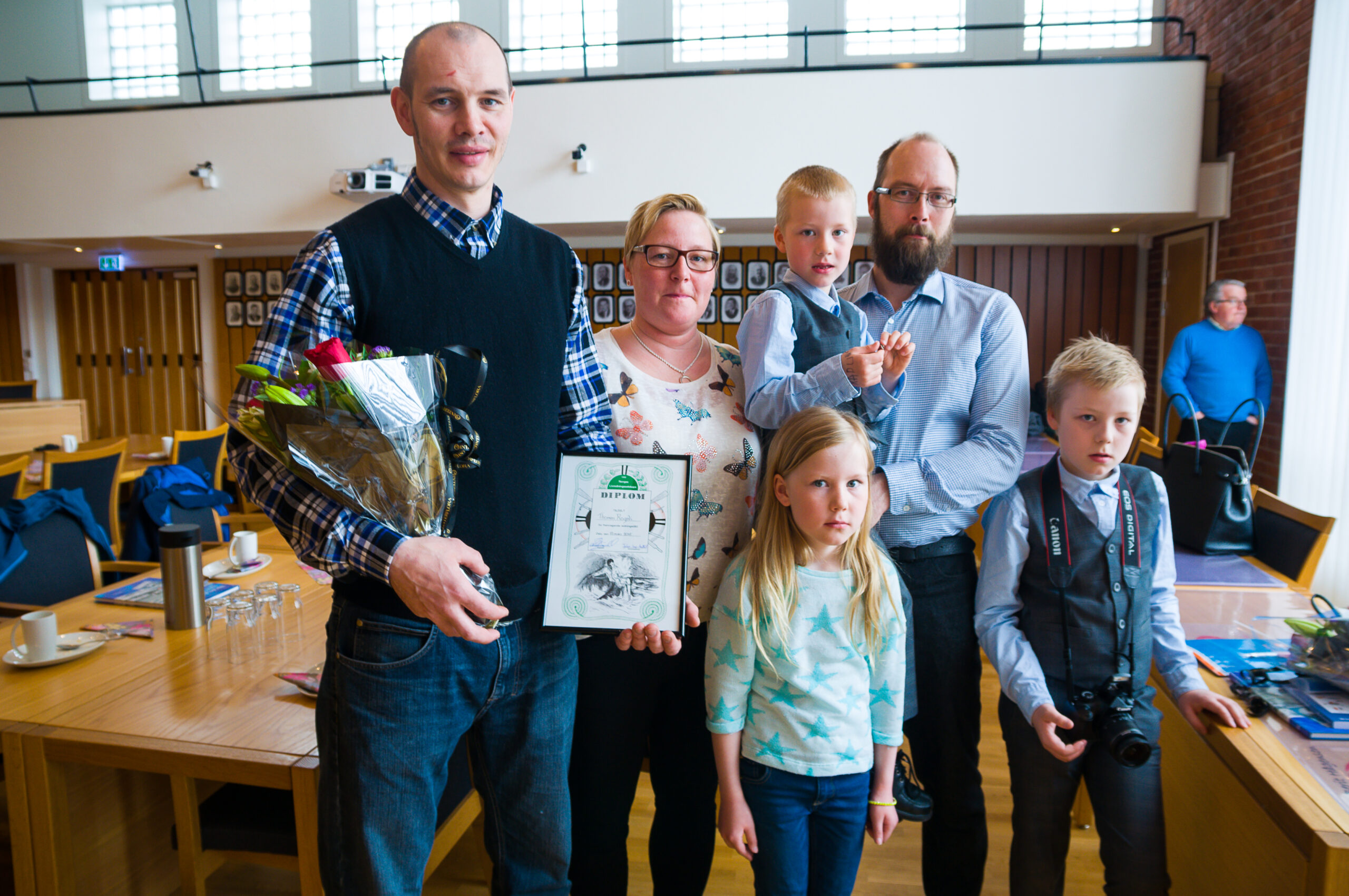 Thomas Rognli med diplom sammen med familien Johansen. Foto: Kristian Østvik